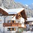 Hotel Burvel innevato con montagne sullo sfondo